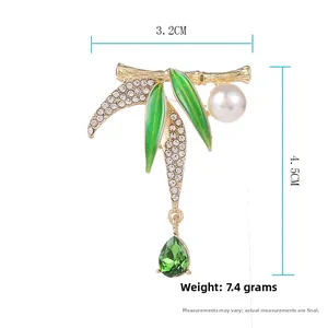 Detailed view of bamboo brooch with green enamel leaves, white pearl and drop crystal