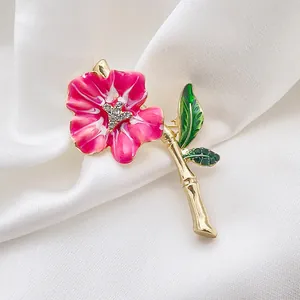 Elegant floral brooch with pink enamel petals and sparkling rhinestones on white silk