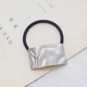 Detail van zilveren vierkante metalen decoratie op zwart elastisch haarstuk