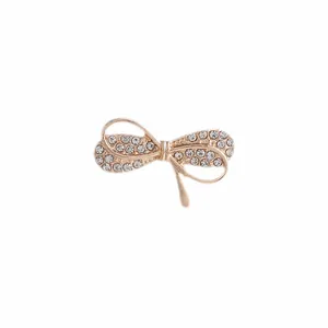 Detalle macro del broche de lazo en oro rosa con brillantes diamantes de imitación y acabado