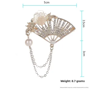 Detailed view of a fan-shaped brooch with rhinestones and floral charm measurements