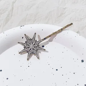 Detailopname van de sprankelende strass ster haarspeld op een artistiek porseleinen bord