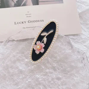 Elegant vintage oval hair clip with pink flowers, pearls and golden leaves on black base