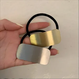 Detailopname van zwarte elastische haarelastiekjes met goud en zilver geborsteld metaal