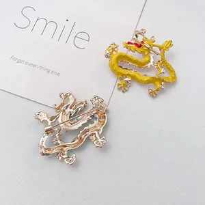 Golden dragon brooch with yellow enamel finish showing front and back pin structure