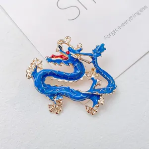 Macro shot of a dragon brooch with blue enamel and gold plating detail and red eyes