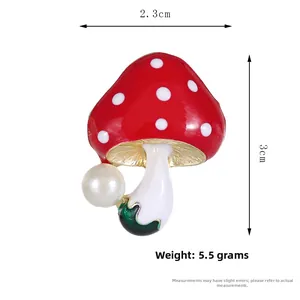 Vue détaillée de la broche champignon en émail rouge avec perle et dimensions de 3cm