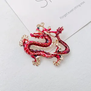 Exquisite Chinese dragon brooch with red enamel and gold-plated finish on a white background