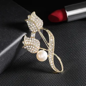 Elegant gold tulip brooch featuring sparkling rhinestones and a white pearl on black background