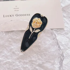 Retro black rose hair clip with gold flower details on crystal ice block base