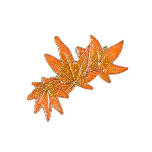 Elegant orange maple leaf hair clip with pearls and glitter finish on white background
