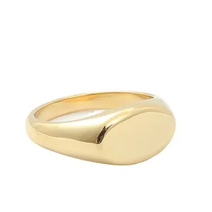 Macro di un anello a sigillo ovale minimalista placcato oro in acciaio lucido