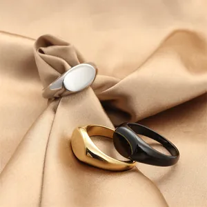 Dettaglio di anelli a sigillo ovali in argento, oro e nero su elegante tessuto di seta