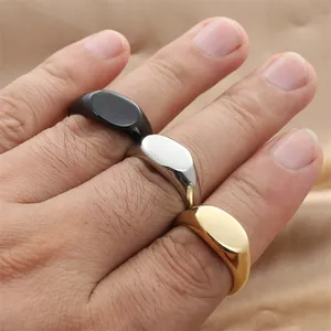 Anelli a sigillo ovali in acciaio lucidato nei colori oro, argento e nero sulla mano