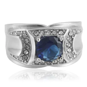 Vista macro de anillo ancho de acero plateado con gema azul grande y pavé de pedrería