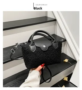 Detail of black faux shearling handbag with leather trim and silver metal buckle closure