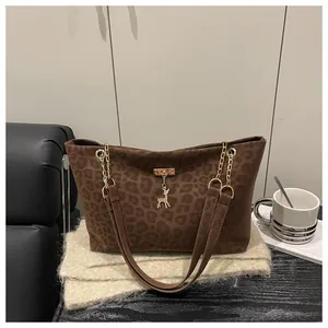 Dettaglio della borsa tote leopardata con ciondolo a cervo dorato e tracolla sottile