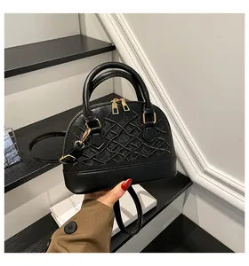 Detail der schwarzen bestickten Muscheltasche mit goldenen Beschlägen und Gurt