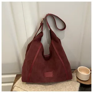 Detail of burgundy suede hobo bag texture on soft knit fabric with coffee cup