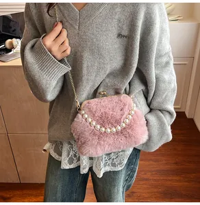 Macro-opname van roze faux fur handtas met parelmoer handvat en gouden metalen sluiting