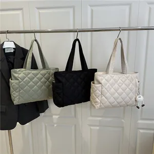 Quilted tote bags in green, black and beige featuring a minimalist diamond stitch design