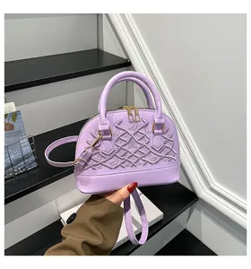 Detail der lila Muscheltasche mit aufwendiger Stickerei und goldfarbenen Reißverschlüssen