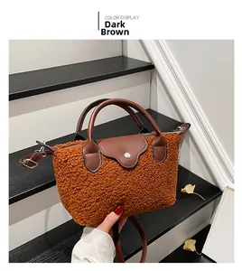 Detailed view of dark brown teddy fleece dumpling bag with leather flap and handle
