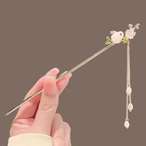 Épingle à cheveux dorée avec lapin blanc, fleurs roses et glands en perles