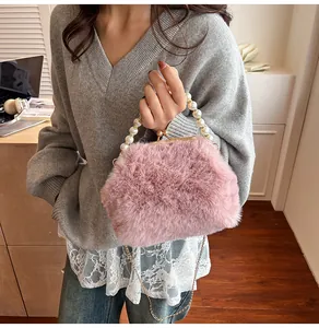 Roze pluche handtas met parelhandvat en gouden ketting in een gezellige omgeving