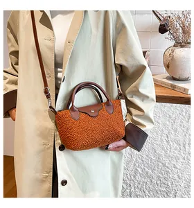 Detail of orange faux shearling handbag with brown leather flap and silver buckle