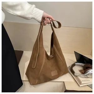 Detail of vintage brown suede tote bag with leather trim and spacious interior capacity