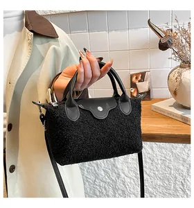 Close-up of black sherpa hobo bag with PU leather handle and silver magnetic snap closure