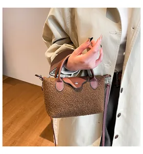 Detail of brown faux shearling and leather trim dumpling bag on a khaki coat