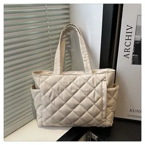 Minimalist beige quilted tote bag with diamond stitching and side pockets for daily commute