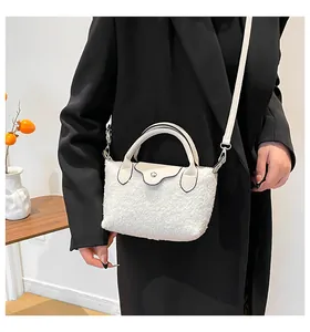 Detail of white plush lamb wool dumpling bag with leather flap and gold metal clasp