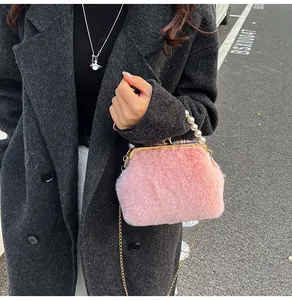 Detail van de roze pluche handtas met parelhandvat en gouden metalen kettingriem