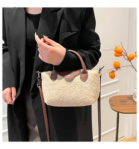 Detail of plush faux fur tote with leather trim and gold-tone hardware accessories