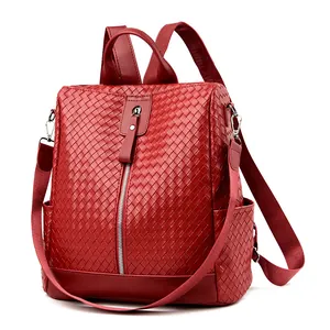 Red woven texture backpack with convertible straps and vertical zipper on white background