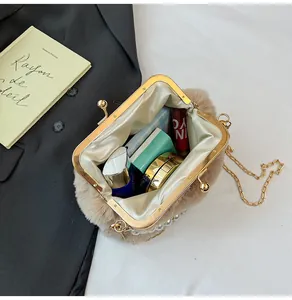Detail van pluche crossbodytas met ruim interieur voor cosmetica en gouden kettingriem