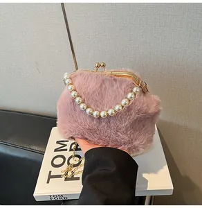 Detail van roze imitatiebont tas met parelhandvat en gouden metalen framesluiting