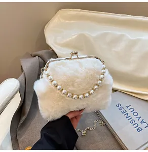 Detail van crème witte faux fur clutch met parelhandvat en gouden knipsluiting