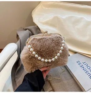 Detailopname van bruine imitatiebonttextuur en de parelgreep van een pluche handtas