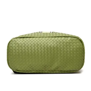 Detail view of woven grass green PU leather backpack with textured base and zipper