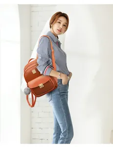 Fashionable brown PU backpack with woven texture and gold lock shown on model