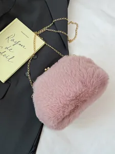 Roze crossbodytas van faux fur met gouden ketting op een zwarte blazer achtergrond