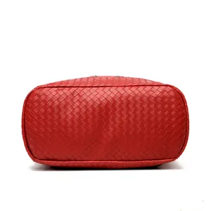 Detail view of red woven leather handbag base with precise stitching and rectangle bottom