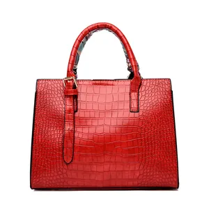 Detail of red crocodile embossed leather tote with elegant floral silk scarf wrap