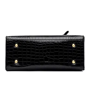 Detail of crocodile pattern handbag base with four protective golden metal feet studs