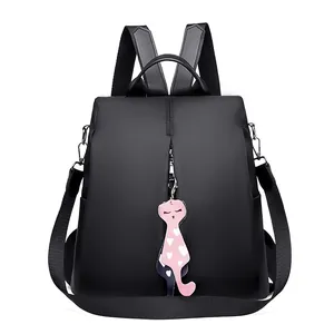 Minimalist black water-resistant nylon backpack with a cute cat pendant and vertical zip