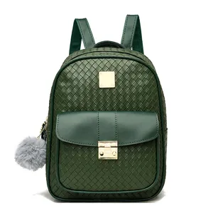 Detailed view of green woven leather backpack with gold metal lock and faux fur pompom